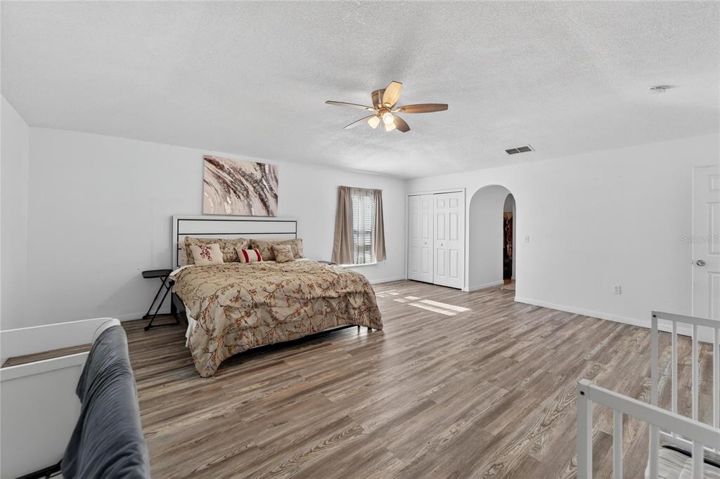 10325 Frog Pond Drive Riverview, FL 33569 - Photo 28 of 53 a bedroom with a bed and a chandelier