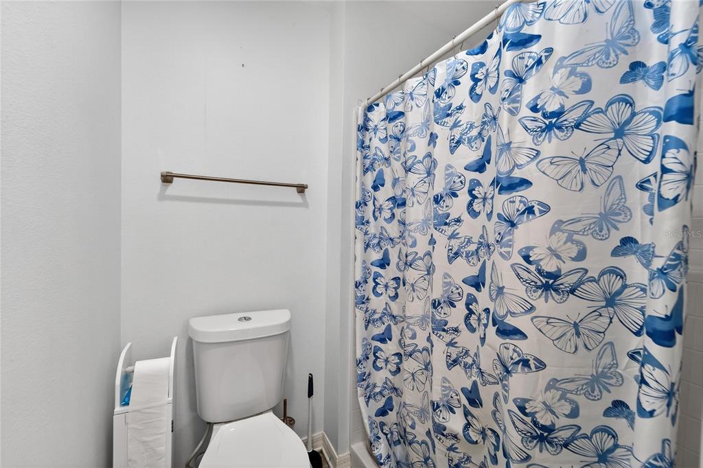 10325 Frog Pond Drive Riverview, FL 33569 - Photo 34 of 53 a white toilet sitting next to a shower curtain