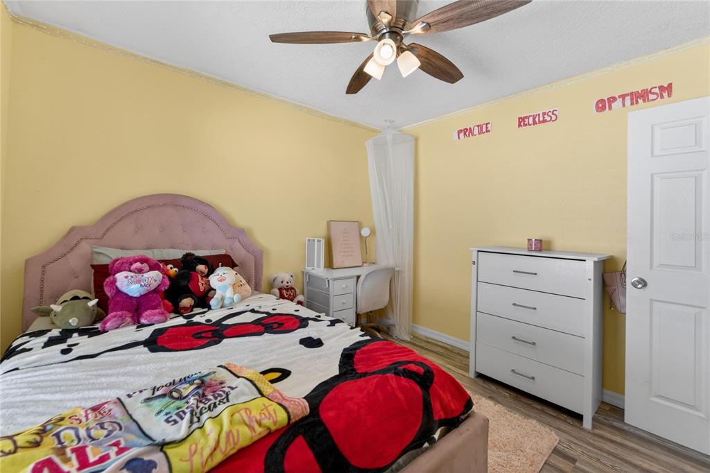 10325 Frog Pond Drive Riverview, FL 33569 - Photo 42 of 53 a bedroom with a bed and wooden floor