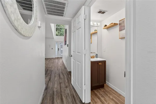 a view of a hallway with wooden floor and entryway