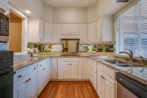 a kitchen with cabinets appliances a sink and a counter top space