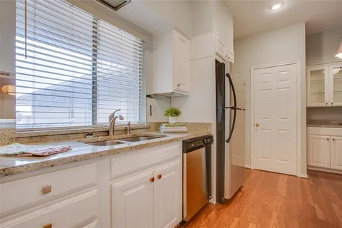 a kitchen with stainless steel appliances granite countertop a sink and a refrigerator