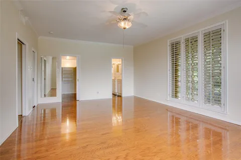 a view of an empty room with a window and wooden floor