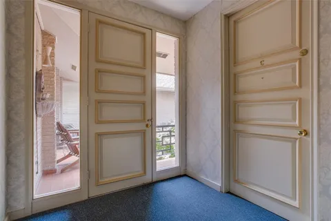 an empty room with wooden floor closet and windows