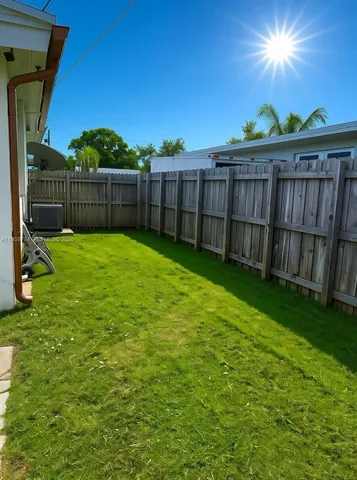 a view of a backyard with wooden fence