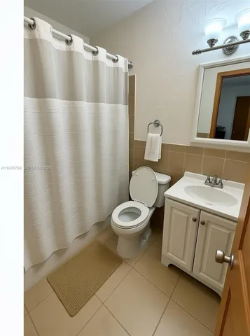 a bathroom with a granite countertop sink toilet and a mirror