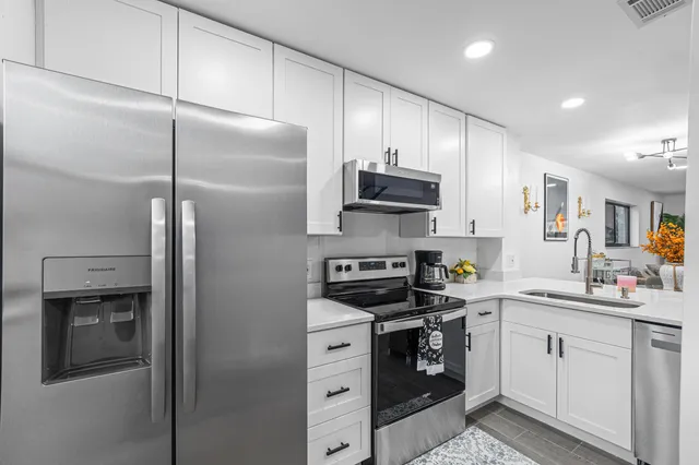 a kitchen with white cabinets and stainless steel appliances