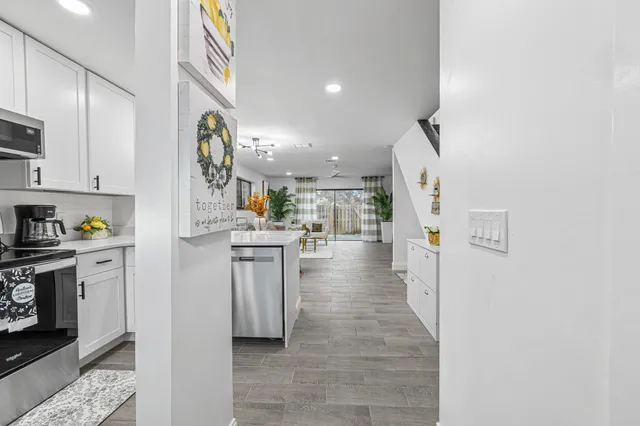 a kitchen with stainless steel appliances a table and chairs