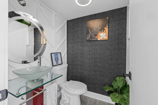 a bathroom with a granite countertop sink a toilet a mirror and shower