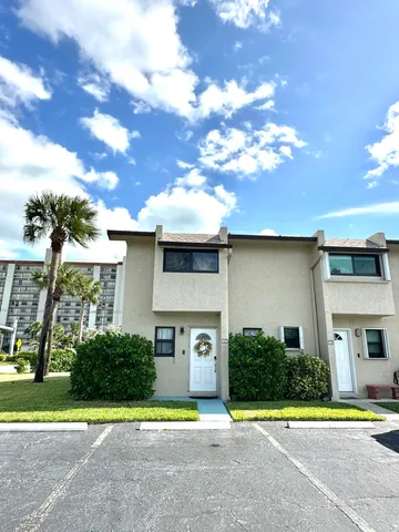 a front view of a house with a garden and trees