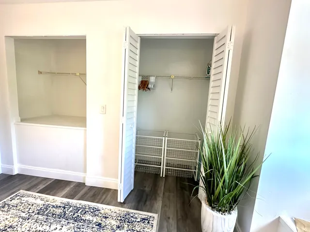 a bedroom with a bed a couch and large window