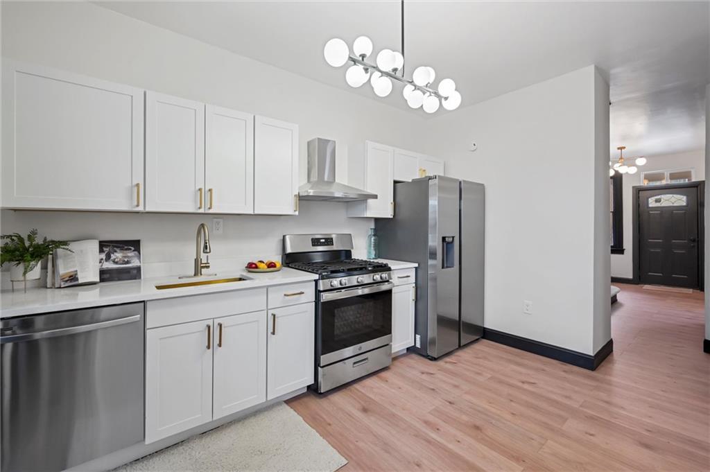8 Marie Avenue Avalon, PA 15202 - Photo 12 of 48 a kitchen with stainless steel appliances granite countertop a refrigerator a sink dishwasher a stove and white cabinets with wooden floor