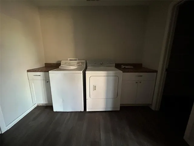 a utility room with wooden floor washer and dryer