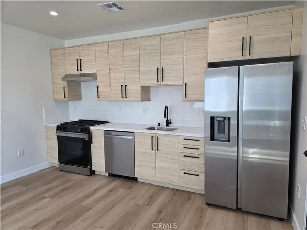 a kitchen with white cabinets and stainless steel appliances