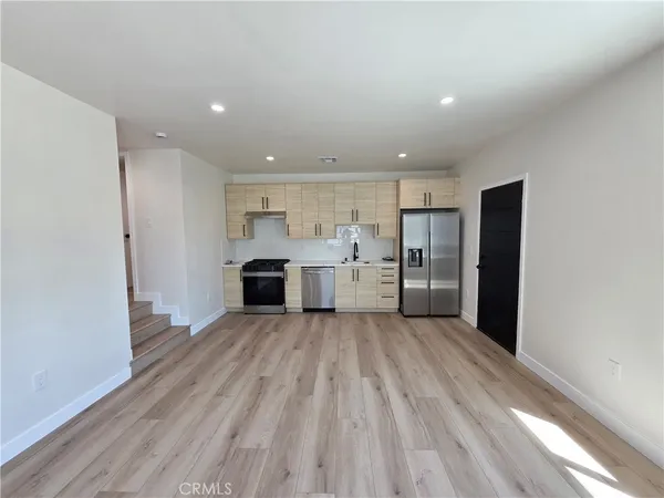 a view of a kitchen with wooden floor and electronic appliances