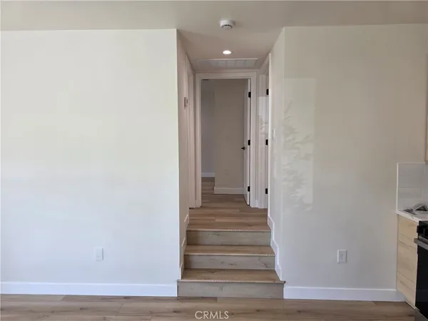 a view of a hallway with wooden floor and staircase