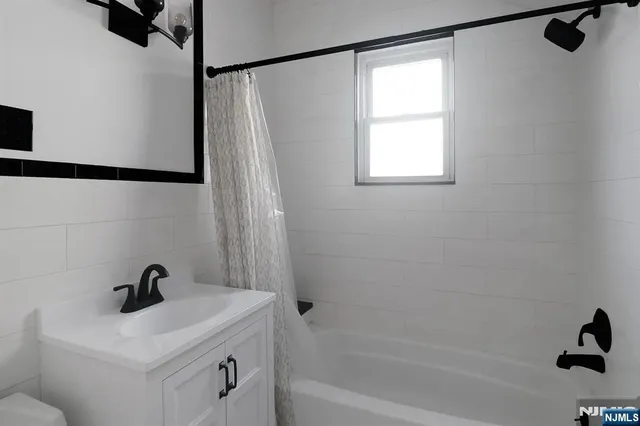 a bathroom with a sink a window and a shower
