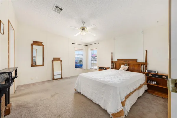 a spacious bedroom with a bed and a chandelier