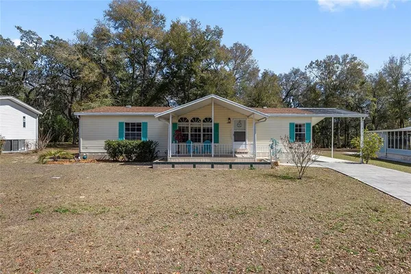 a view of a house with backyard and chairs