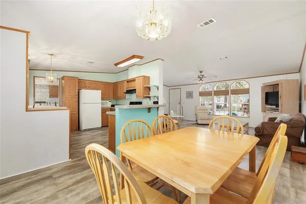 a dining room with furniture a chandelier and wooden floor