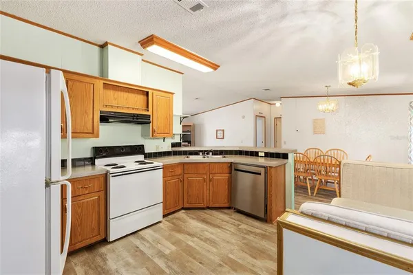 a kitchen with stainless steel appliances granite countertop a sink a stove and a refrigerator
