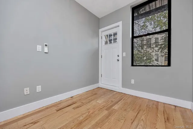 an empty room with wooden floor and a window