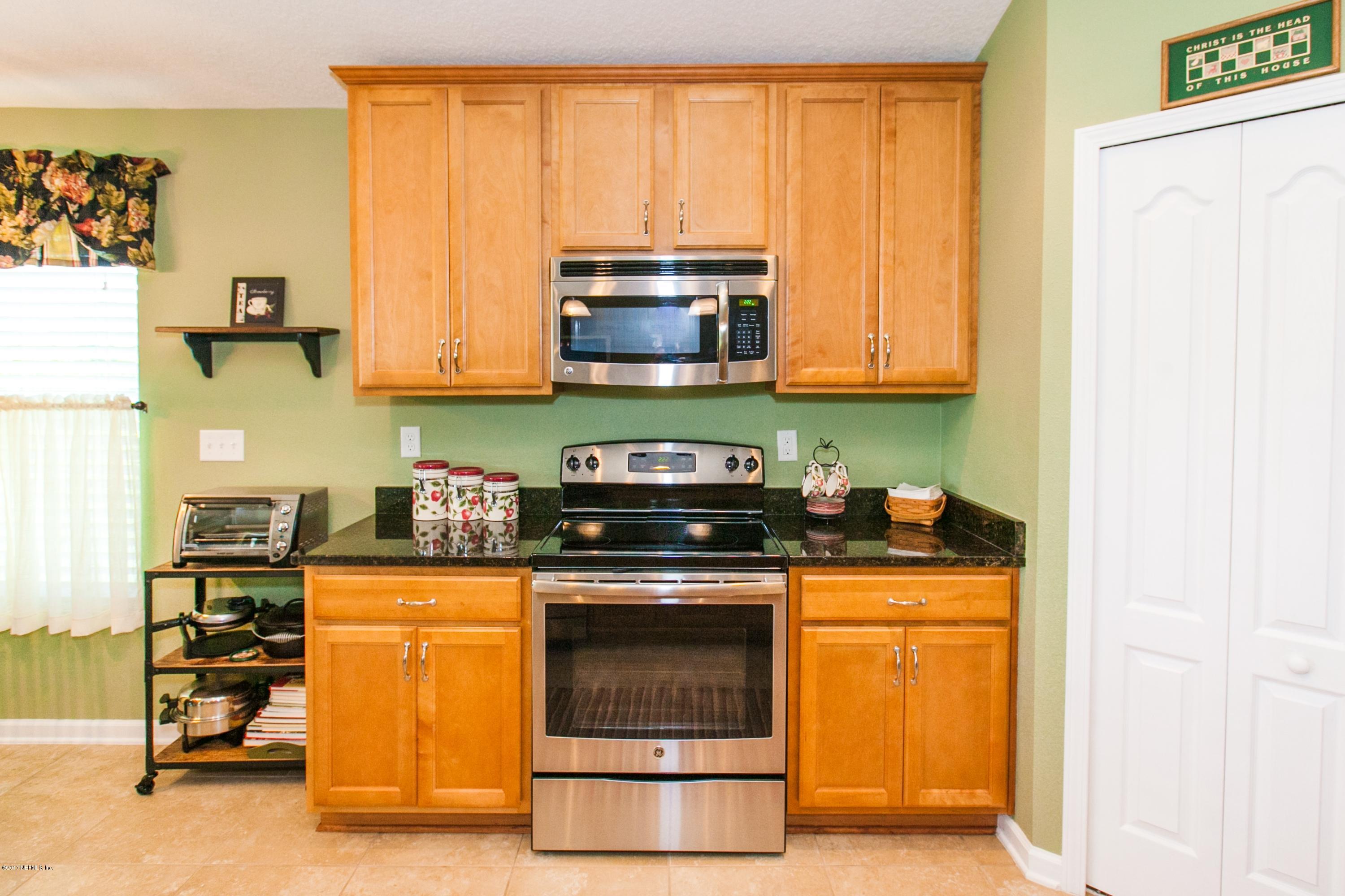 490 Irish Rose Road St. Augustine, FL 32092 - Photo 12 of 44 a kitchen with granite countertop a stove and a microwave