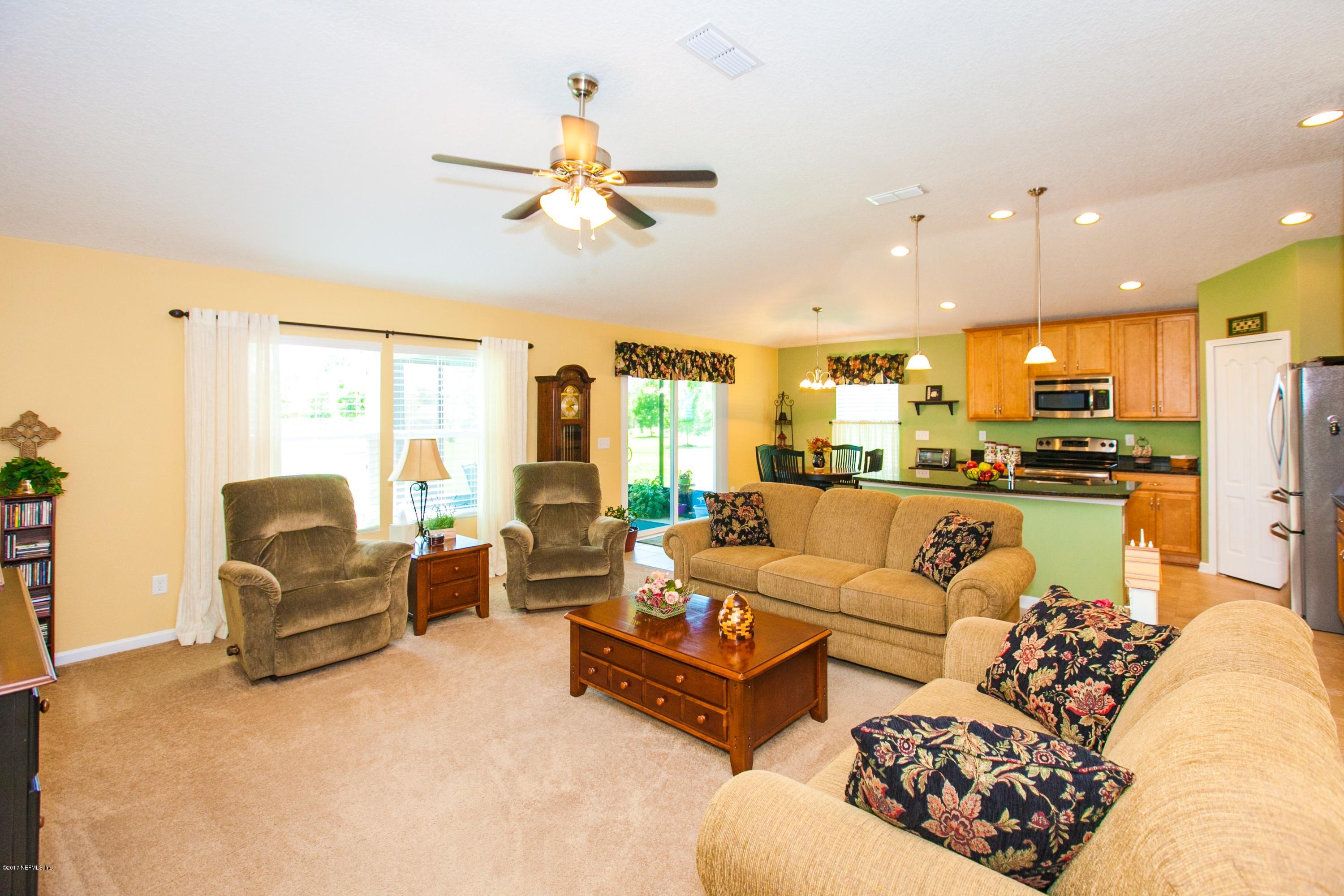 490 Irish Rose Road St. Augustine, FL 32092 - Photo 14 of 44 a living room with furniture kitchen view and a large window