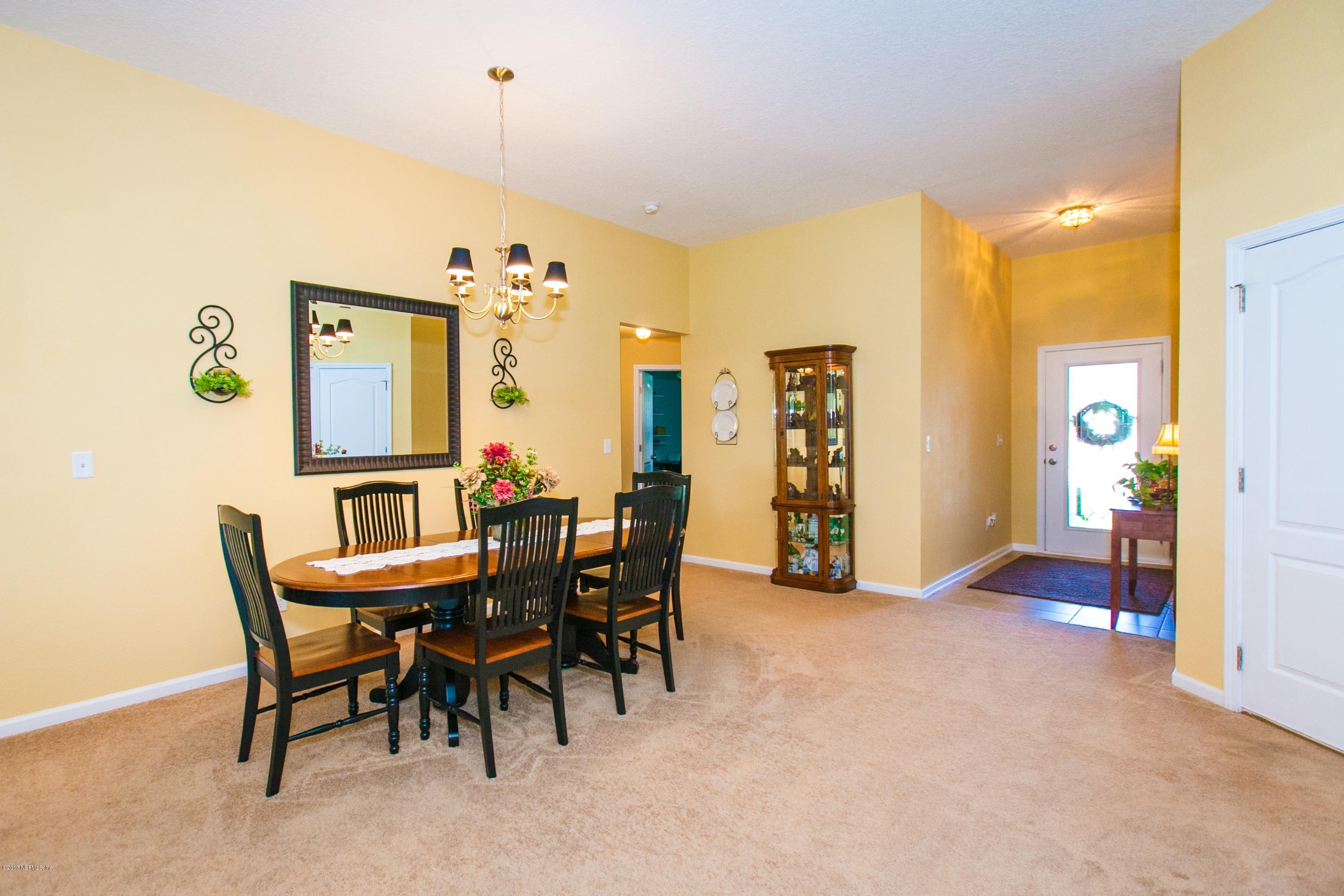 490 Irish Rose Road St. Augustine, FL 32092 - Photo 16 of 44 a view of a dining room with furniture and a chandelier
