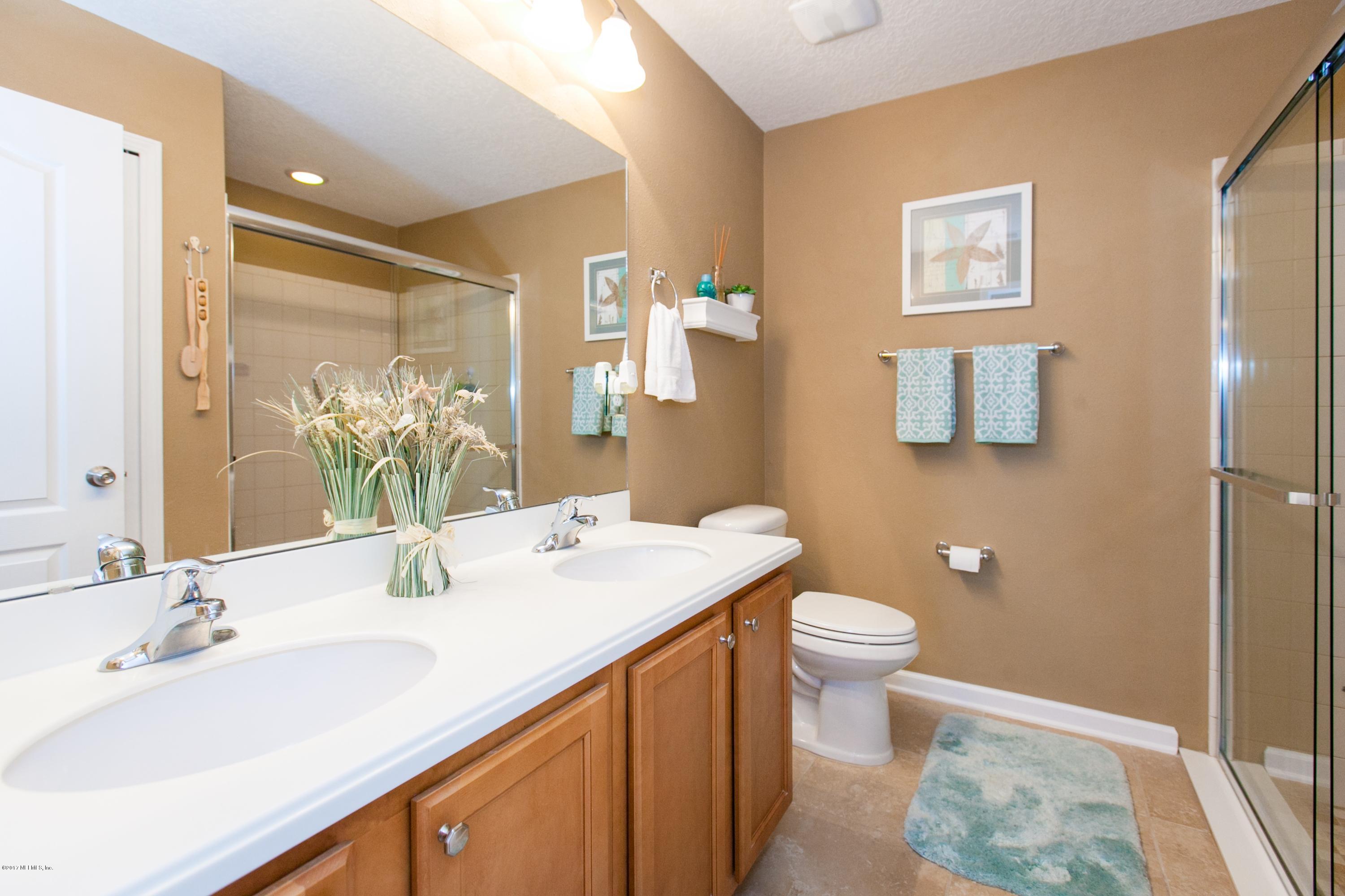 490 Irish Rose Road St. Augustine, FL 32092 - Photo 20 of 44 a bathroom with a sink and mirror with toilet