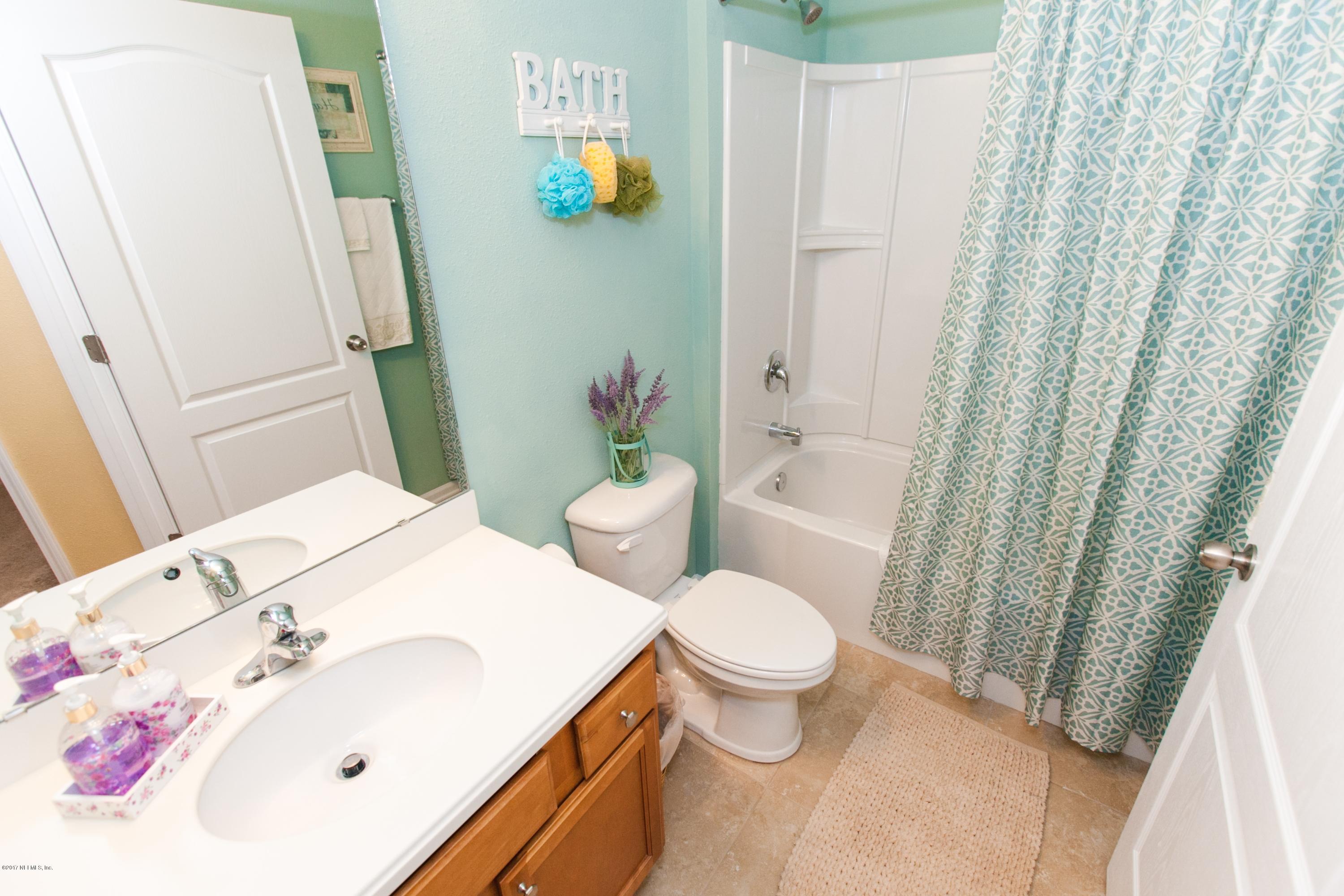 490 Irish Rose Road St. Augustine, FL 32092 - Photo 25 of 44 a bathroom with a sink a toilet and shower curtain
