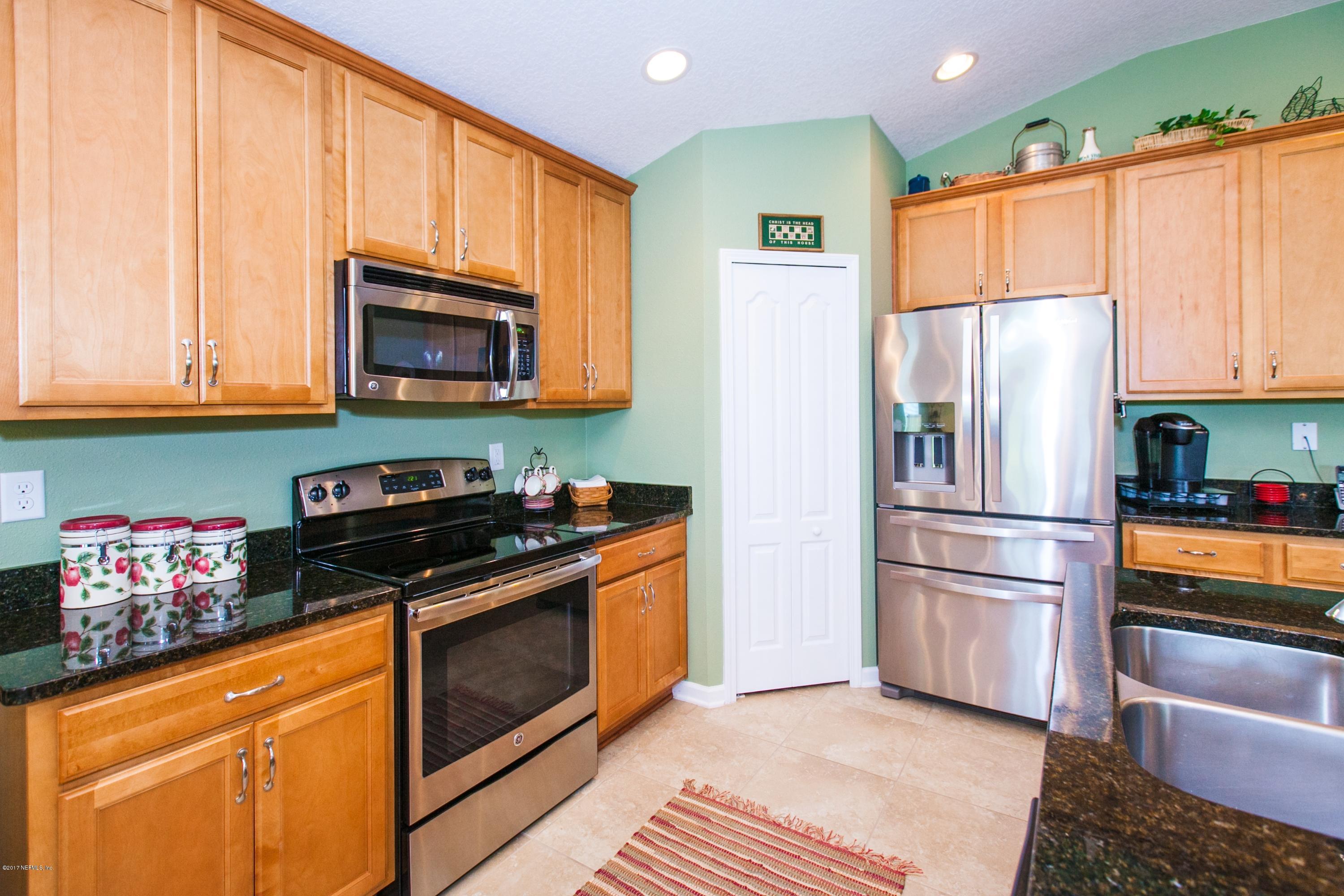 490 Irish Rose Road St. Augustine, FL 32092 - Photo 10 of 44 a kitchen with granite countertop wooden cabinets stainless steel appliances and a window