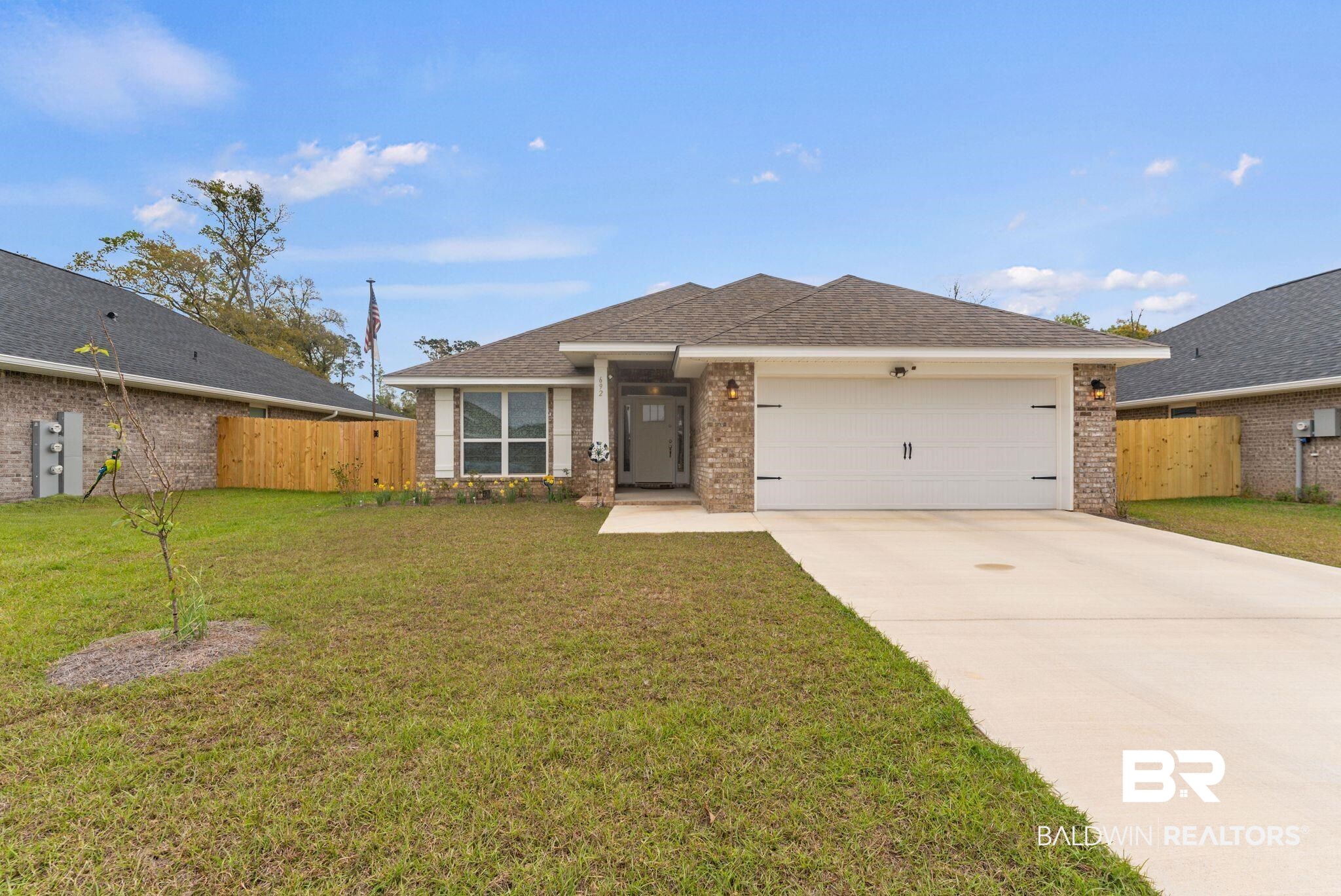 692 Mayflower Drive Foley, AL 36535 - Photo 1 of 40 Ranch-style home with an attached garage, concrete driveway, brick siding, and roof with shingles