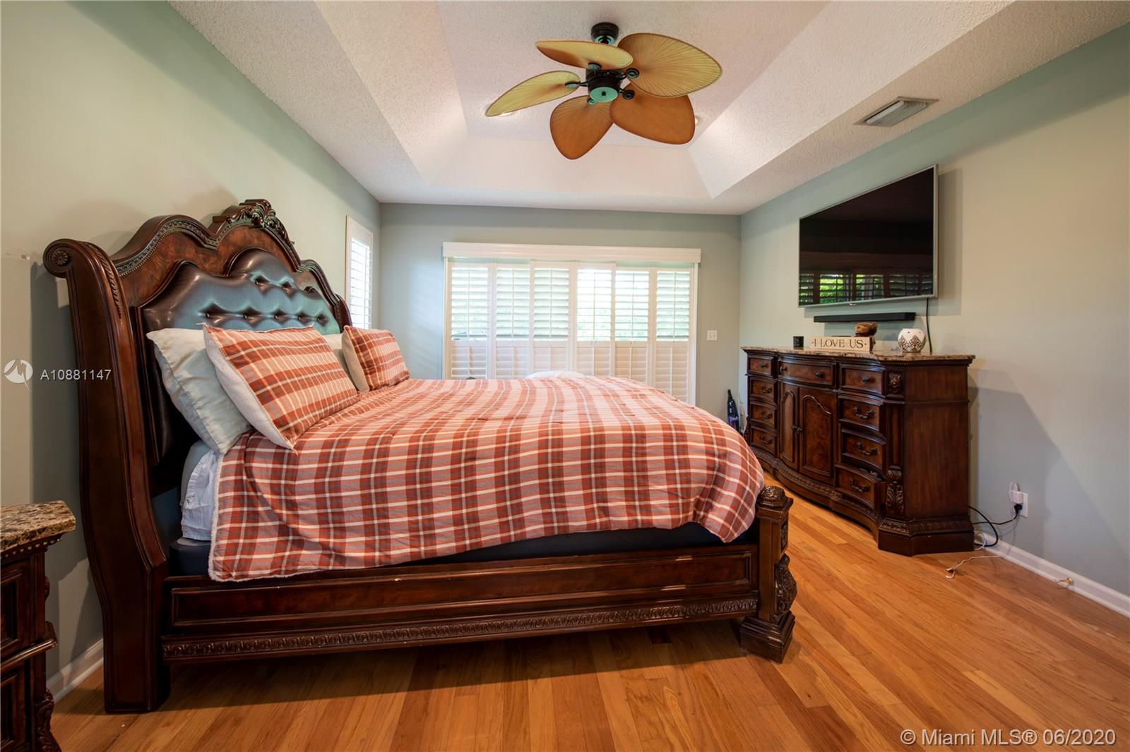 12346 Baywind Court Boca Raton, FL 33428 - Photo 18 of 31 a bed sitting in a bedroom next to a window with a flat screen tv