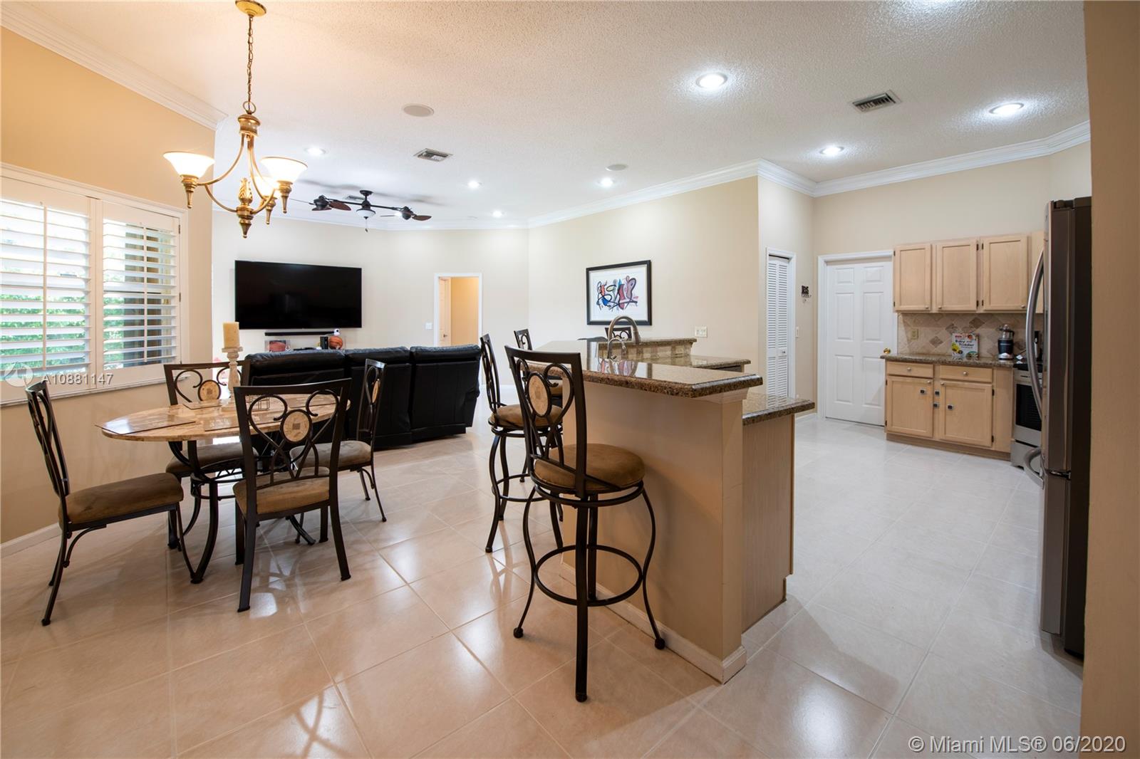 12346 Baywind Court Boca Raton, FL 33428 - Photo 8 of 31 a view of a dining room and livingroom with furniture wooden floor a flat screen tv