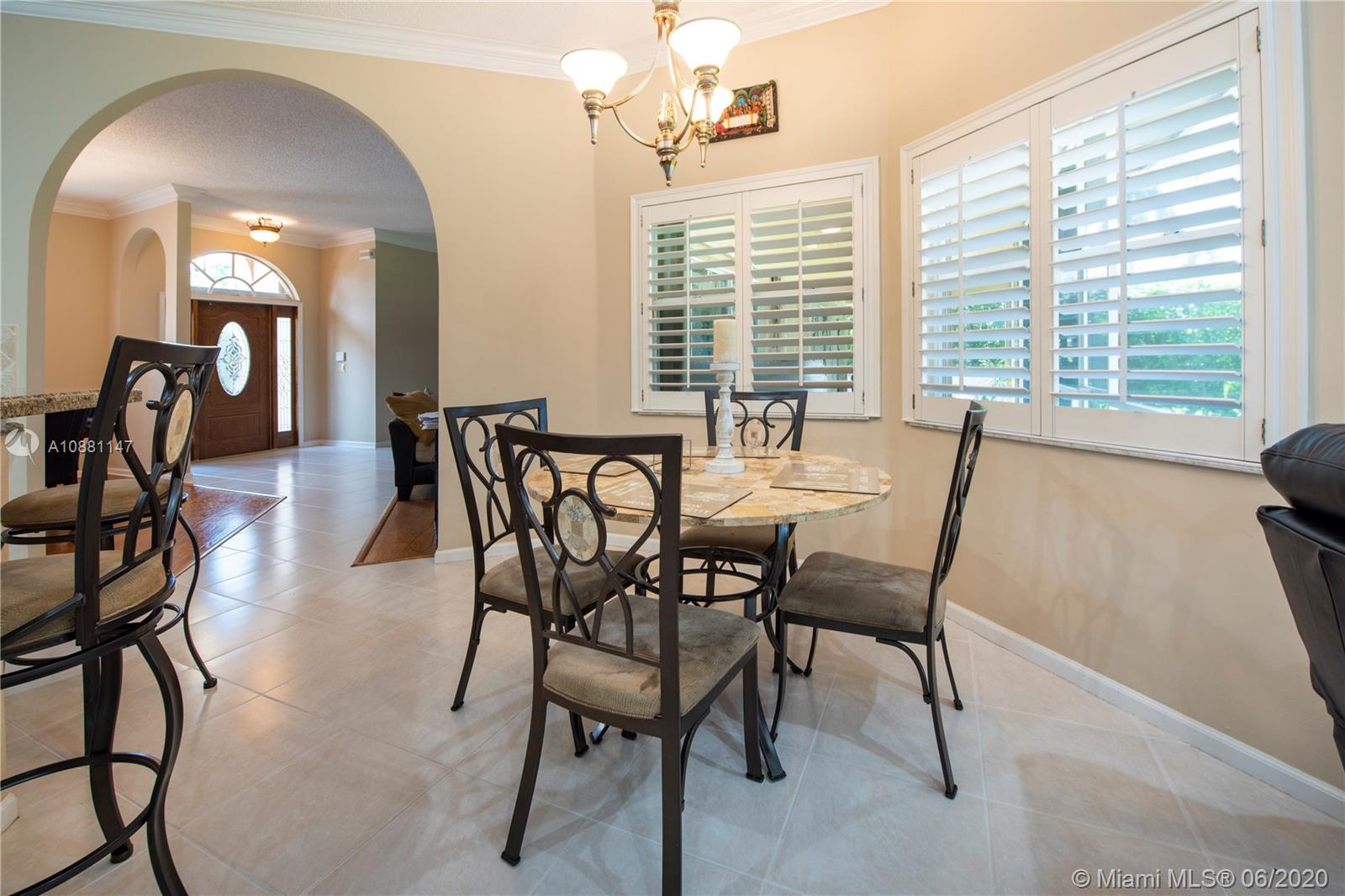 12346 Baywind Court Boca Raton, FL 33428 - Photo 9 of 31 a view of a dining room with furniture and a chandelier