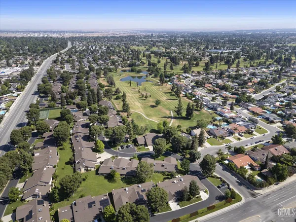 an aerial view of a residential houses with yard