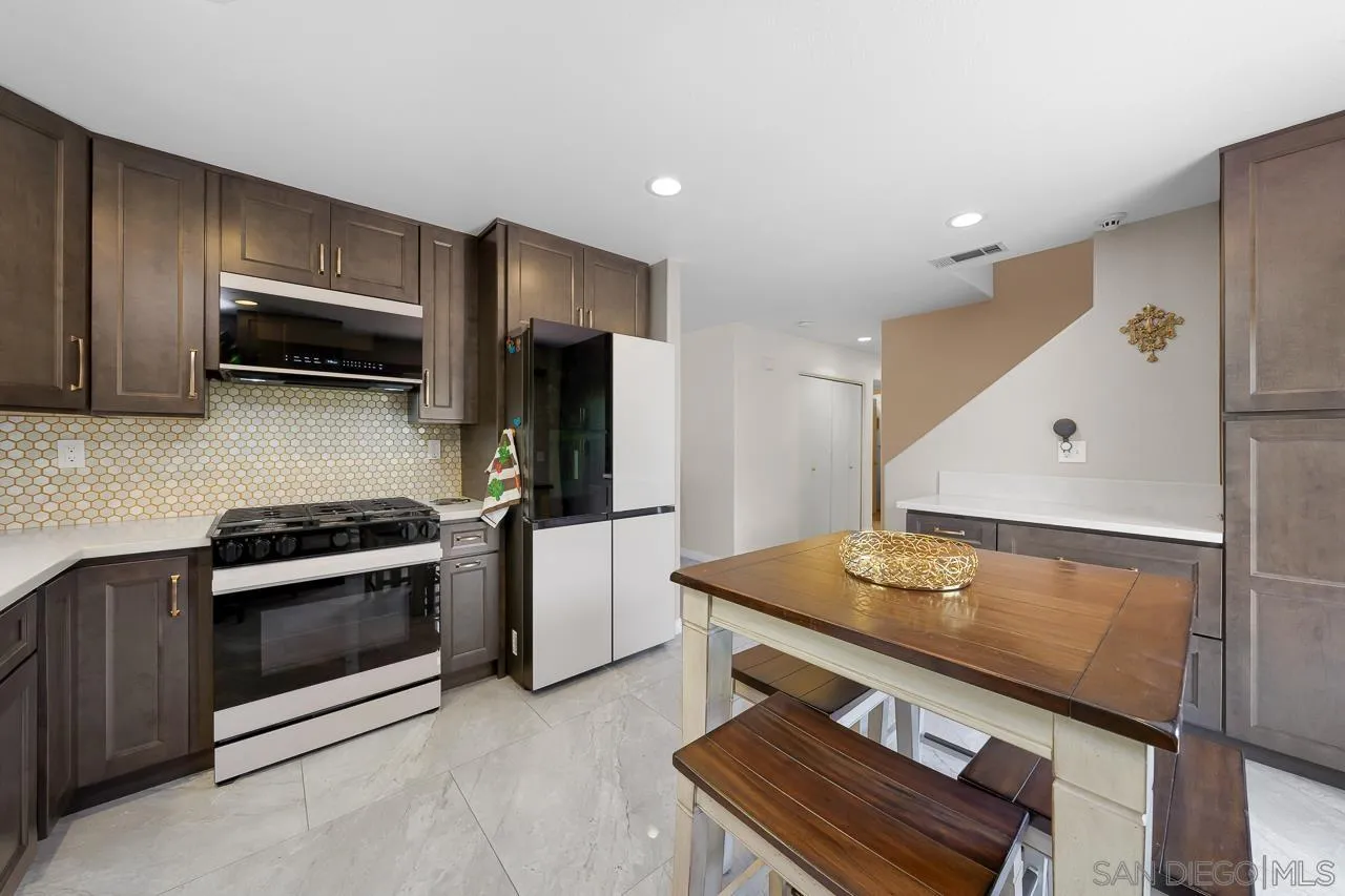 1631 Applegate Street Chula Vista, CA 91913 - Photo 17 of 34 a kitchen with stainless steel appliances kitchen island granite countertop a stove and a refrigerator
