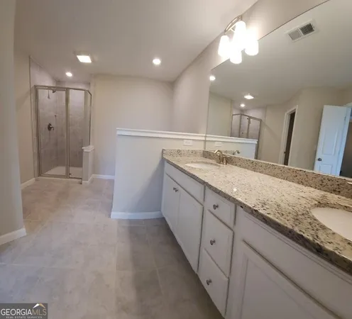 a spacious bathroom with a granite countertop sink a mirror and a vanity