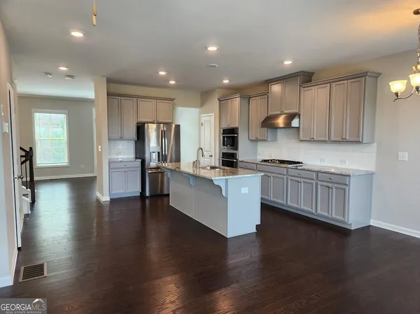 a kitchen with a refrigerator and a stove top oven