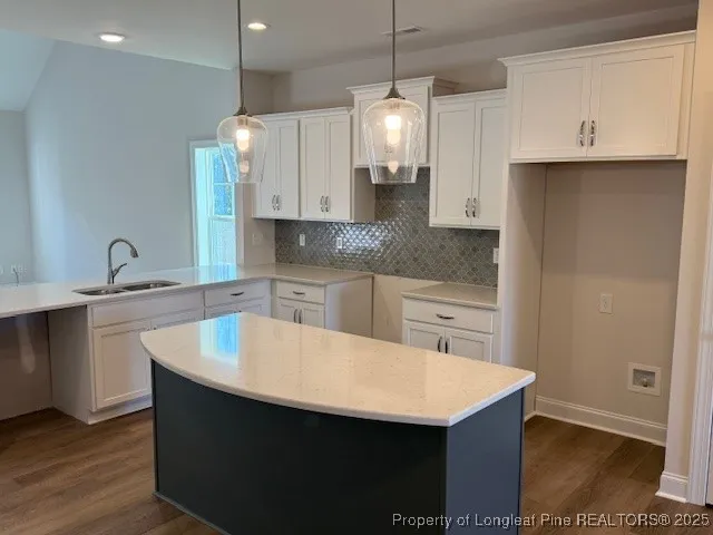 a kitchen with kitchen island a sink dishwasher a stove and a refrigerator with wooden floor