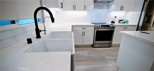 a kitchen with a sink and a stove top oven