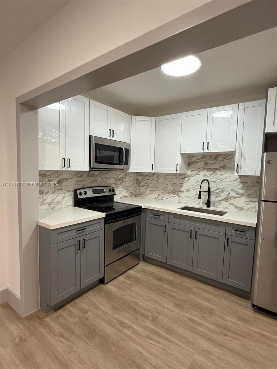 a kitchen with granite countertop a stove top oven sink and cabinets