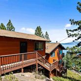 a view of a house with wooden deck and furniture