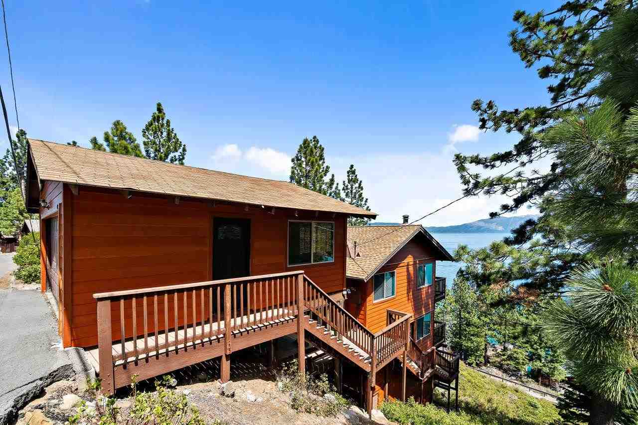 a view of a house with wooden deck and furniture