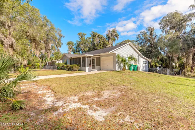 a view of house with yard and swimming pool