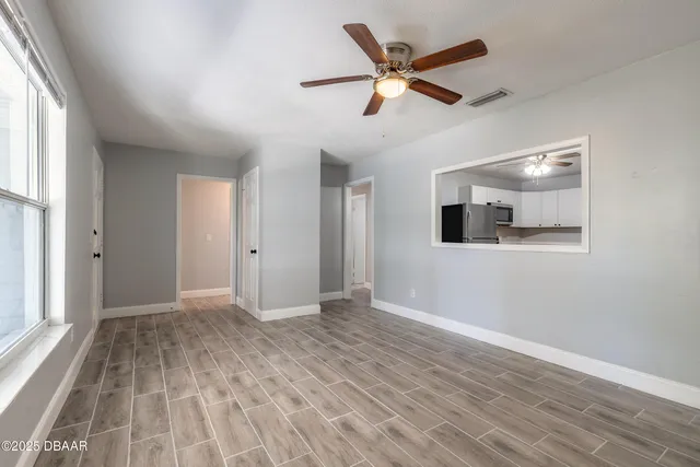 an empty room with wooden floor and windows