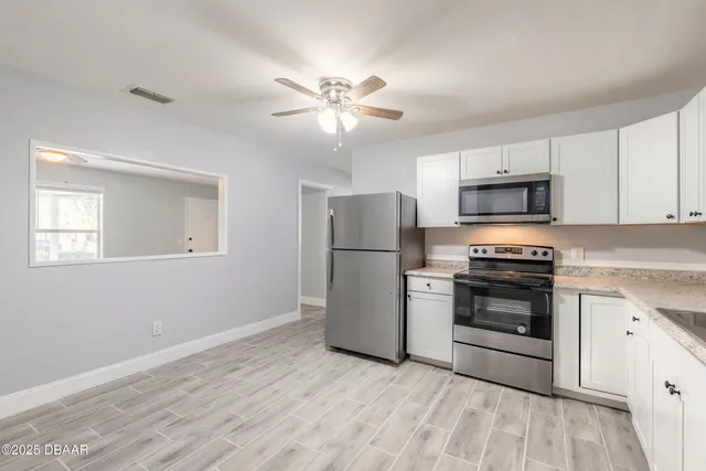 a kitchen with a refrigerator stove and white cabinets