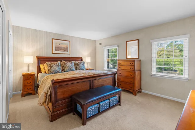 a bedroom with a bed and a dresser next to a window