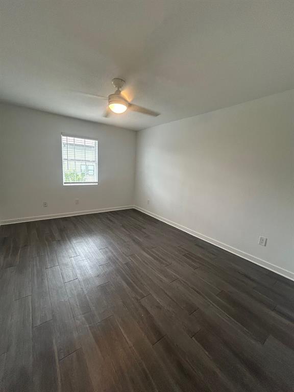 321 East 8th Street, Unit 208 Dallas, TX 75203 - Photo 6 of 9 Spacious room featuring wood-finish flooring, a ceiling fan with integrated lighting, white walls, and a window with blinds